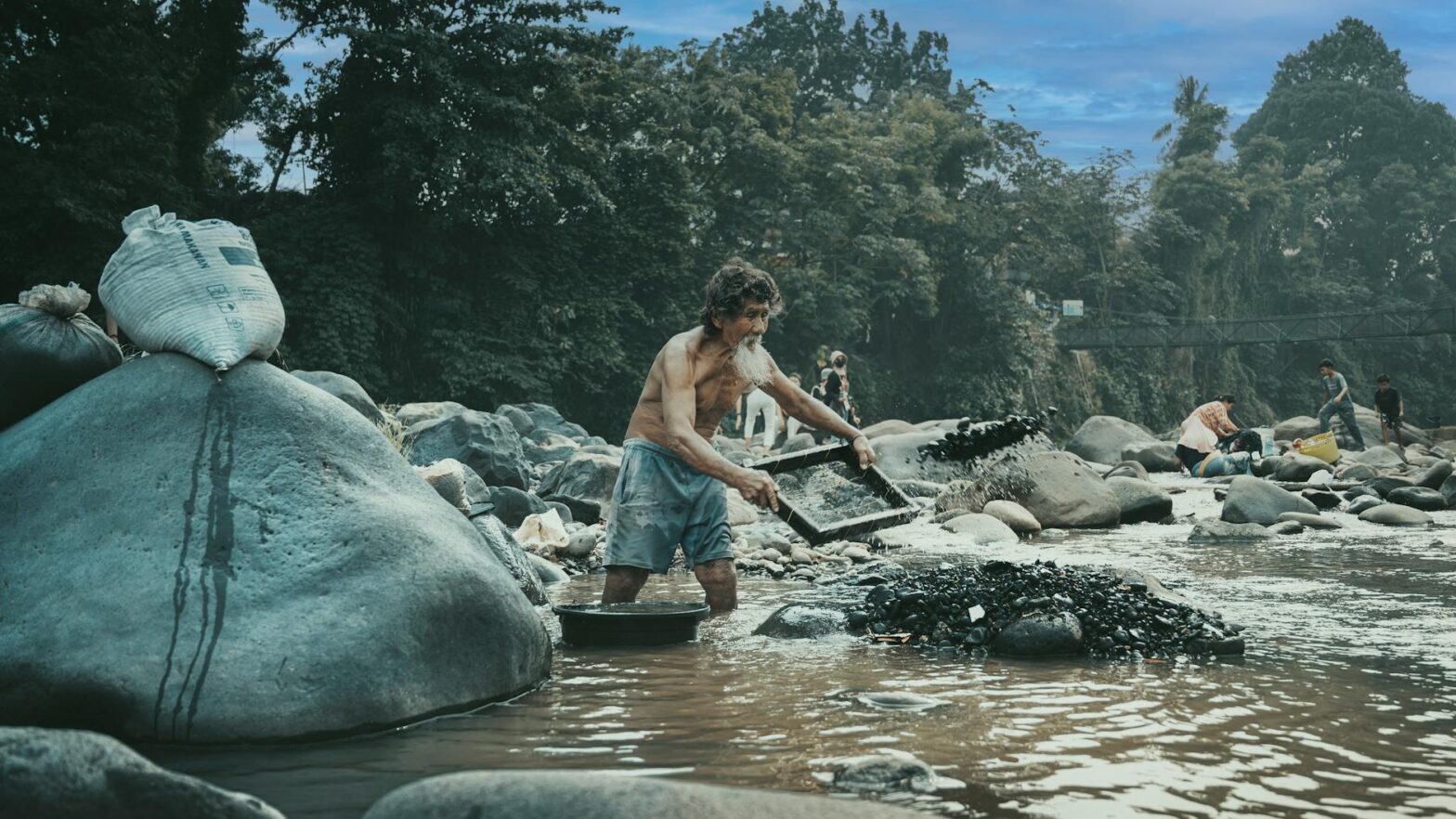 man panning for gold in indonesian river